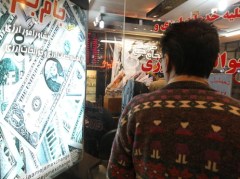 A man looks at the rates outside a currency exchange in a shop in Tehran